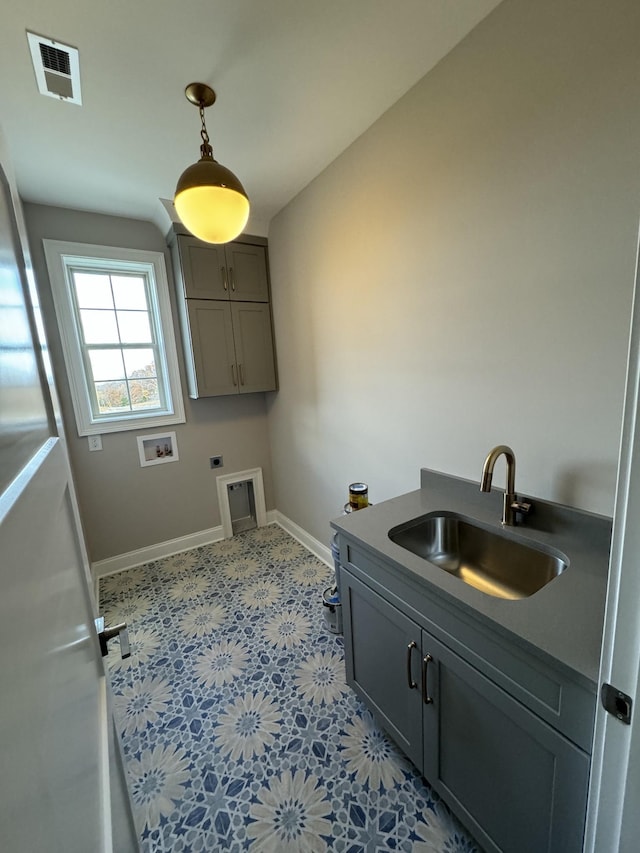 laundry area featuring cabinet space, visible vents, baseboards, a sink, and electric dryer hookup