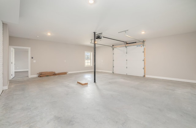 garage with a garage door opener, recessed lighting, and baseboards