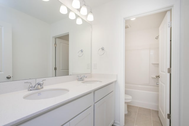 bathroom featuring double vanity, a sink, toilet, and tile patterned floors