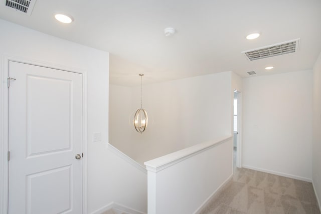 corridor featuring recessed lighting, visible vents, light carpet, and an upstairs landing