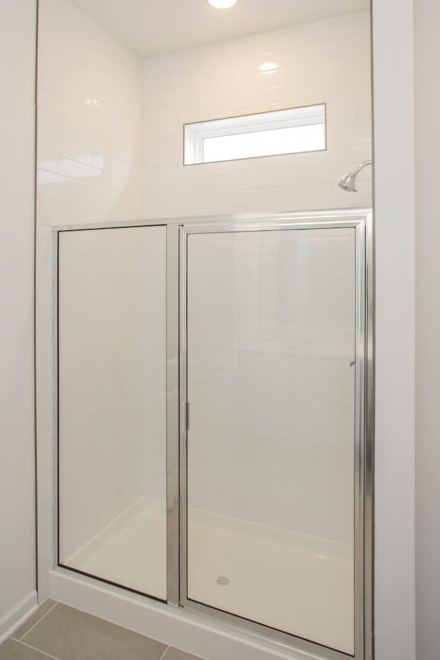 full bathroom featuring a stall shower and tile patterned floors