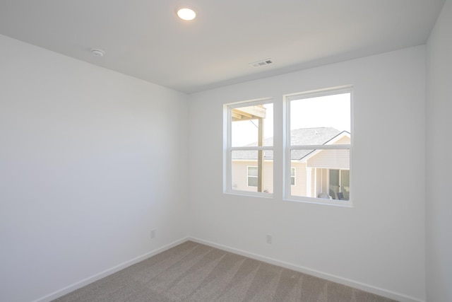 spare room featuring light carpet, visible vents, baseboards, and recessed lighting