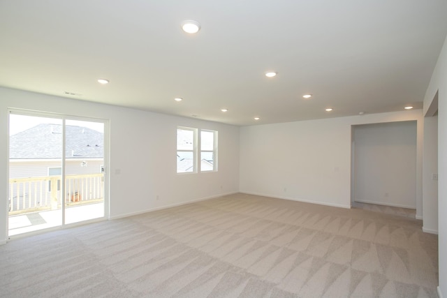 spare room with light carpet, plenty of natural light, and recessed lighting