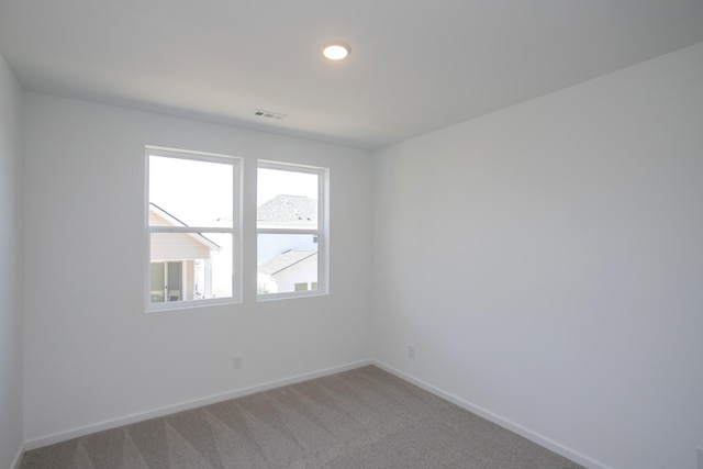 empty room with light colored carpet, visible vents, baseboards, and recessed lighting