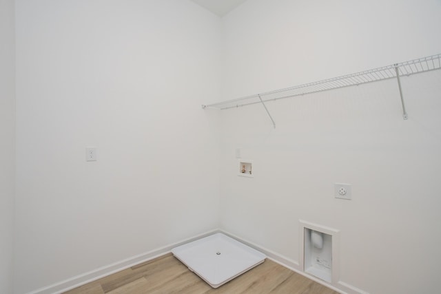 clothes washing area with hookup for a washing machine, hookup for an electric dryer, laundry area, baseboards, and light wood-style floors