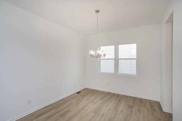 unfurnished room featuring light wood-type flooring, visible vents, a notable chandelier, and baseboards