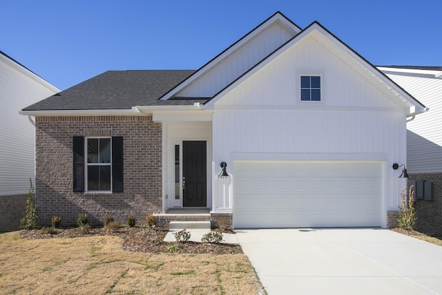 view of front facade with an attached garage, a shingled roof, concrete driveway, and brick siding