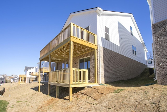 view of side of property with brick siding and a deck