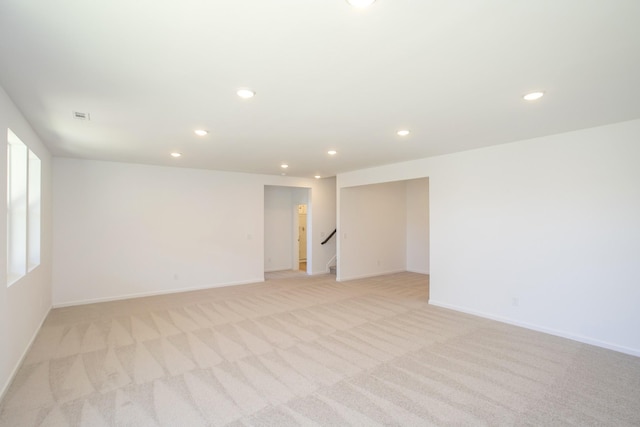 empty room with recessed lighting, light carpet, and baseboards