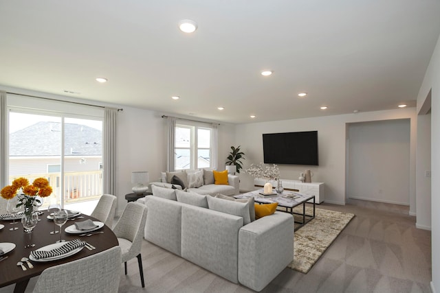 living area with recessed lighting, a healthy amount of sunlight, light carpet, and baseboards