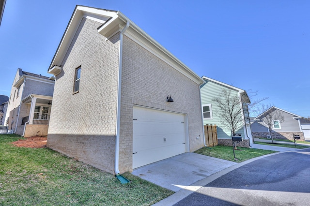 view of home's exterior featuring a garage, driveway, a lawn, and brick siding