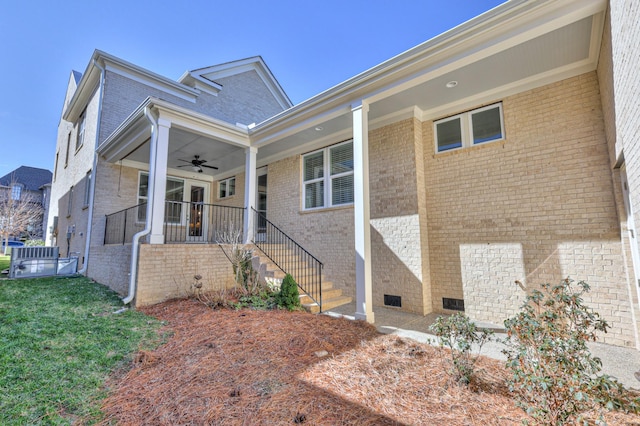 exterior space with a yard, brick siding, crawl space, and a ceiling fan