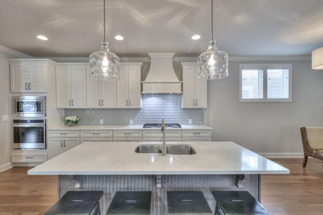 kitchen with stainless steel appliances, custom range hood, a sink, and crown molding