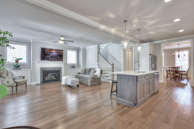 kitchen featuring stainless steel appliances, hardwood / wood-style floors, a sink, and crown molding