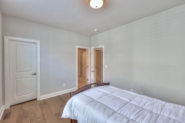 bedroom featuring baseboards and wood finished floors