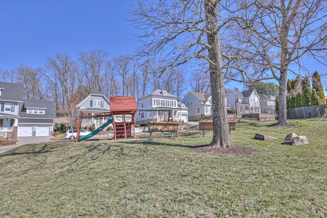 exterior space with an attached garage, a playground, and a residential view