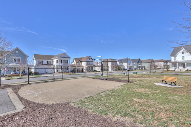 view of property's community featuring community basketball court, a residential view, fence, and a yard