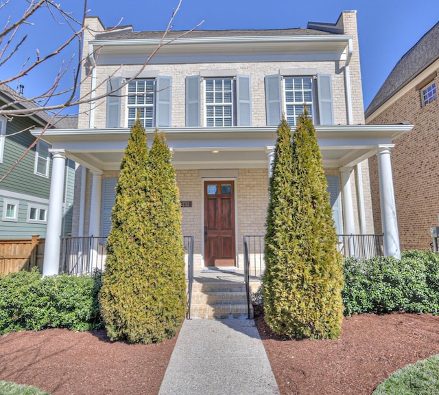 view of front of house featuring a porch and brick siding