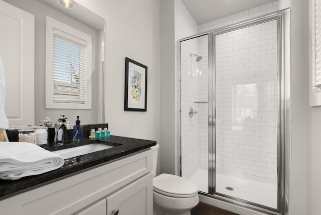 full bath featuring a stall shower, vanity, and toilet