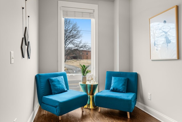 sitting room with baseboards and wood finished floors