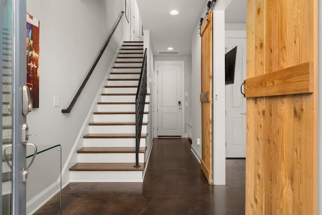 entryway with recessed lighting, finished concrete flooring, baseboards, and a barn door