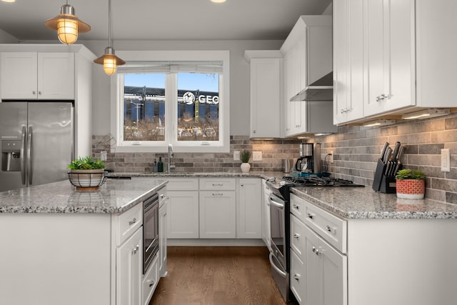 kitchen featuring appliances with stainless steel finishes, white cabinets, and decorative light fixtures