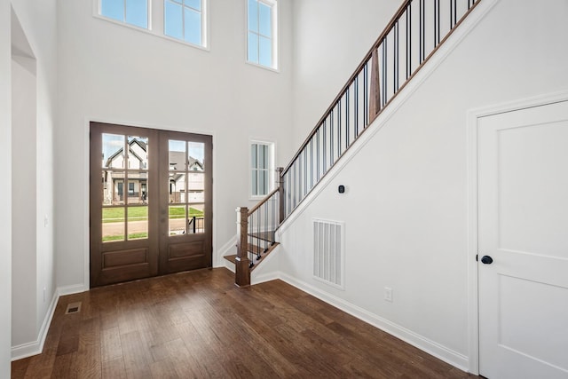 foyer entrance with baseboards, visible vents, dark wood-style floors, stairway, and french doors