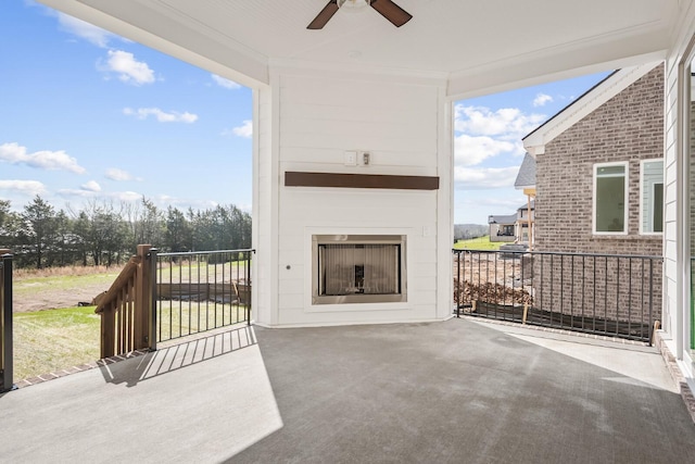 view of patio / terrace featuring ceiling fan and exterior fireplace