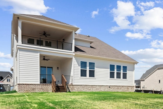 back of property featuring brick siding, a shingled roof, a lawn, ceiling fan, and a balcony