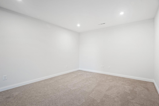 spare room featuring carpet floors, baseboards, visible vents, and recessed lighting