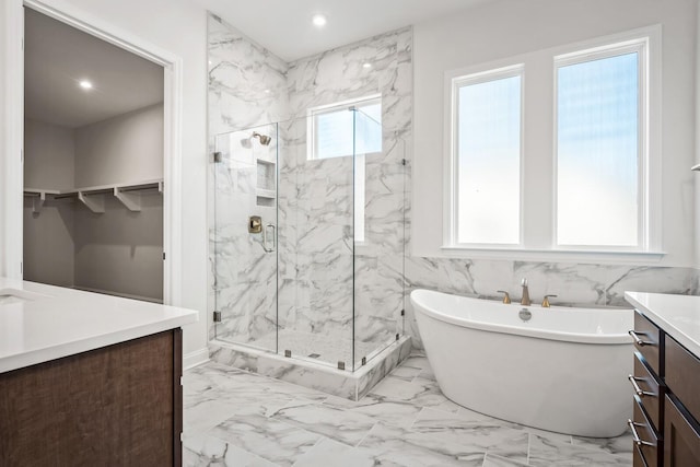 full bathroom with marble finish floor, a freestanding bath, vanity, and a marble finish shower