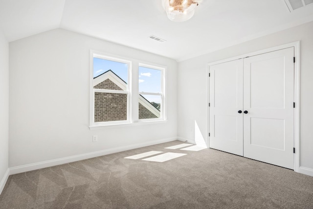 unfurnished bedroom with light carpet, baseboards, and lofted ceiling