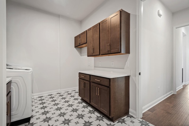 washroom featuring washer / dryer, cabinet space, baseboards, and light floors