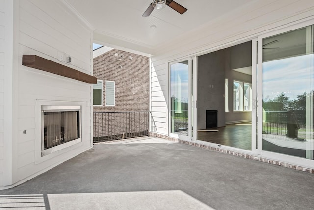 view of patio featuring exterior fireplace and a ceiling fan