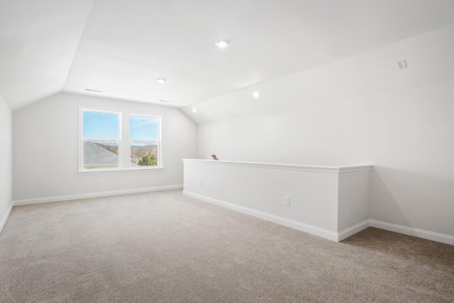 additional living space featuring lofted ceiling, baseboards, and carpet