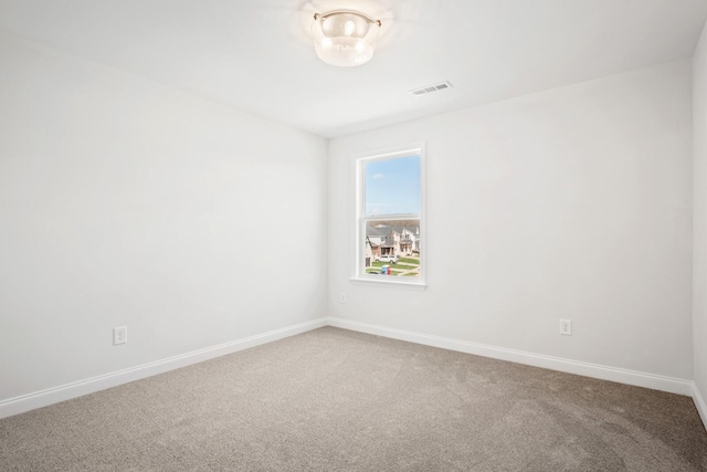 carpeted empty room featuring visible vents and baseboards