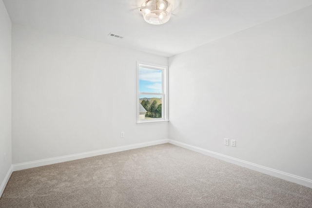 empty room featuring carpet floors, visible vents, and baseboards