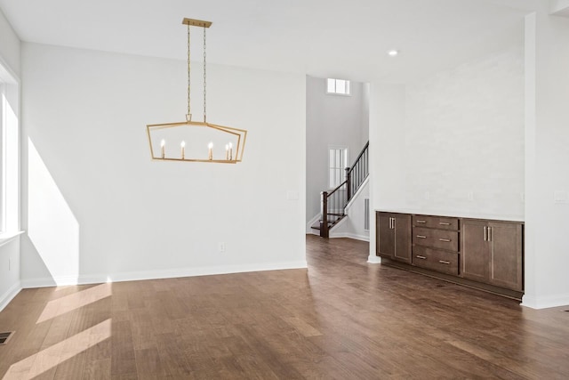 spare room featuring recessed lighting, visible vents, baseboards, stairway, and dark wood-style floors