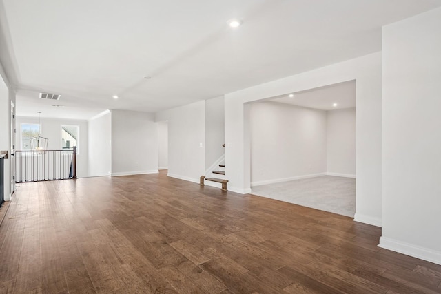 unfurnished living room featuring dark wood-type flooring, recessed lighting, visible vents, and baseboards