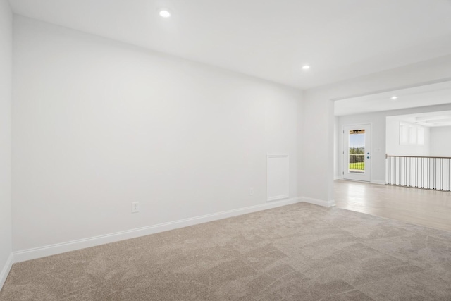 empty room with light carpet, baseboards, and recessed lighting