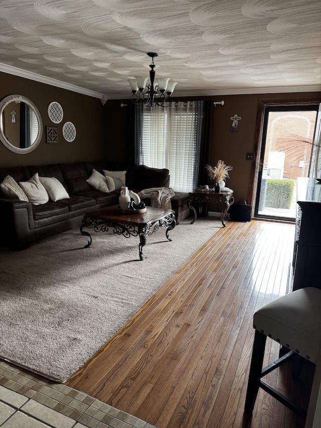 living area featuring a chandelier, ornamental molding, and wood-type flooring