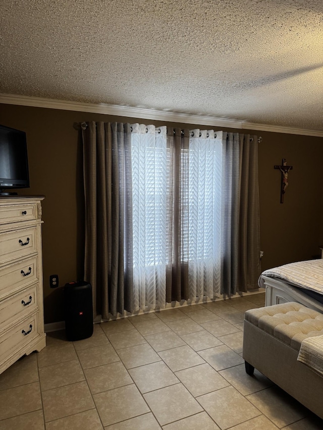 bedroom with light tile patterned floors, ornamental molding, and a textured ceiling