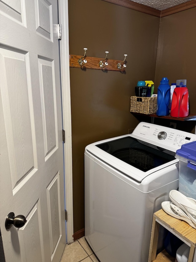 clothes washing area featuring washer / dryer, laundry area, and light tile patterned flooring