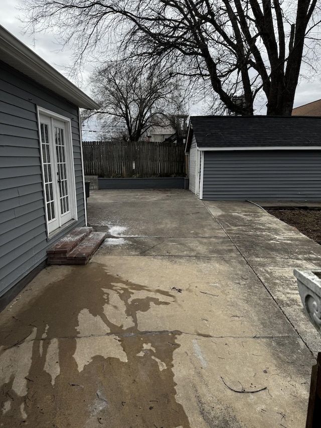 view of patio / terrace featuring entry steps, fence, and an outdoor structure