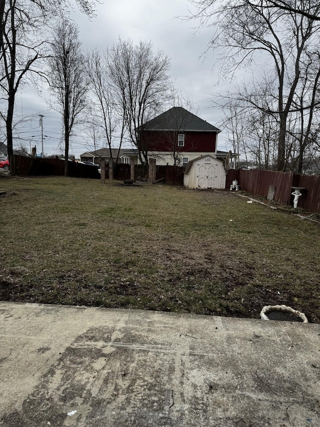 view of yard with a shed, fence, and an outbuilding