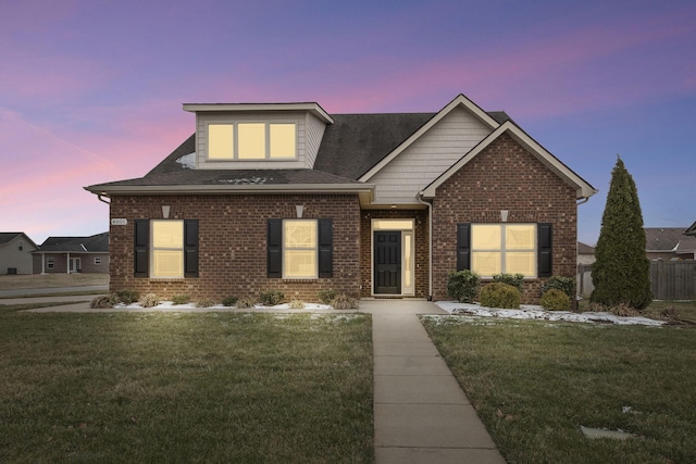 view of front of property with a yard and brick siding