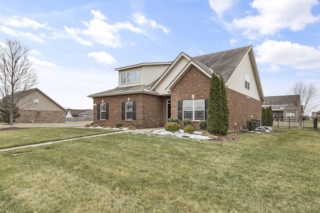 view of front of home featuring brick siding, a front yard, and fence