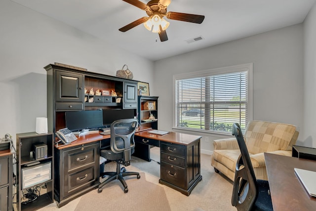 home office with light colored carpet, baseboards, a ceiling fan, and visible vents