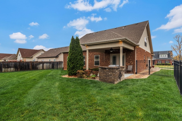 back of house featuring ceiling fan, a yard, a fenced backyard, a patio, and brick siding