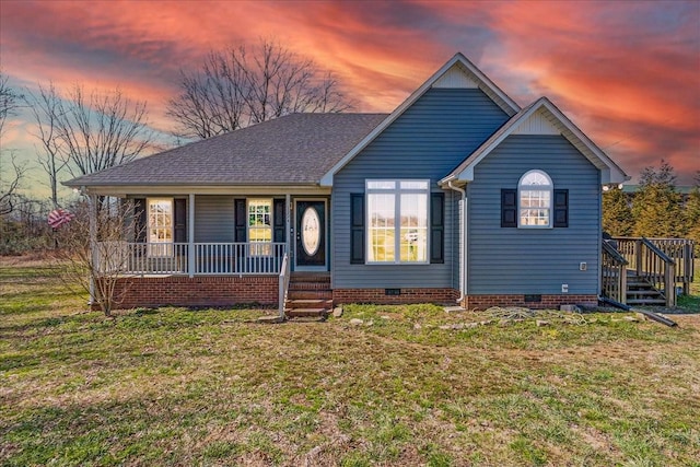 view of front of house with a shingled roof, crawl space, covered porch, and a front lawn